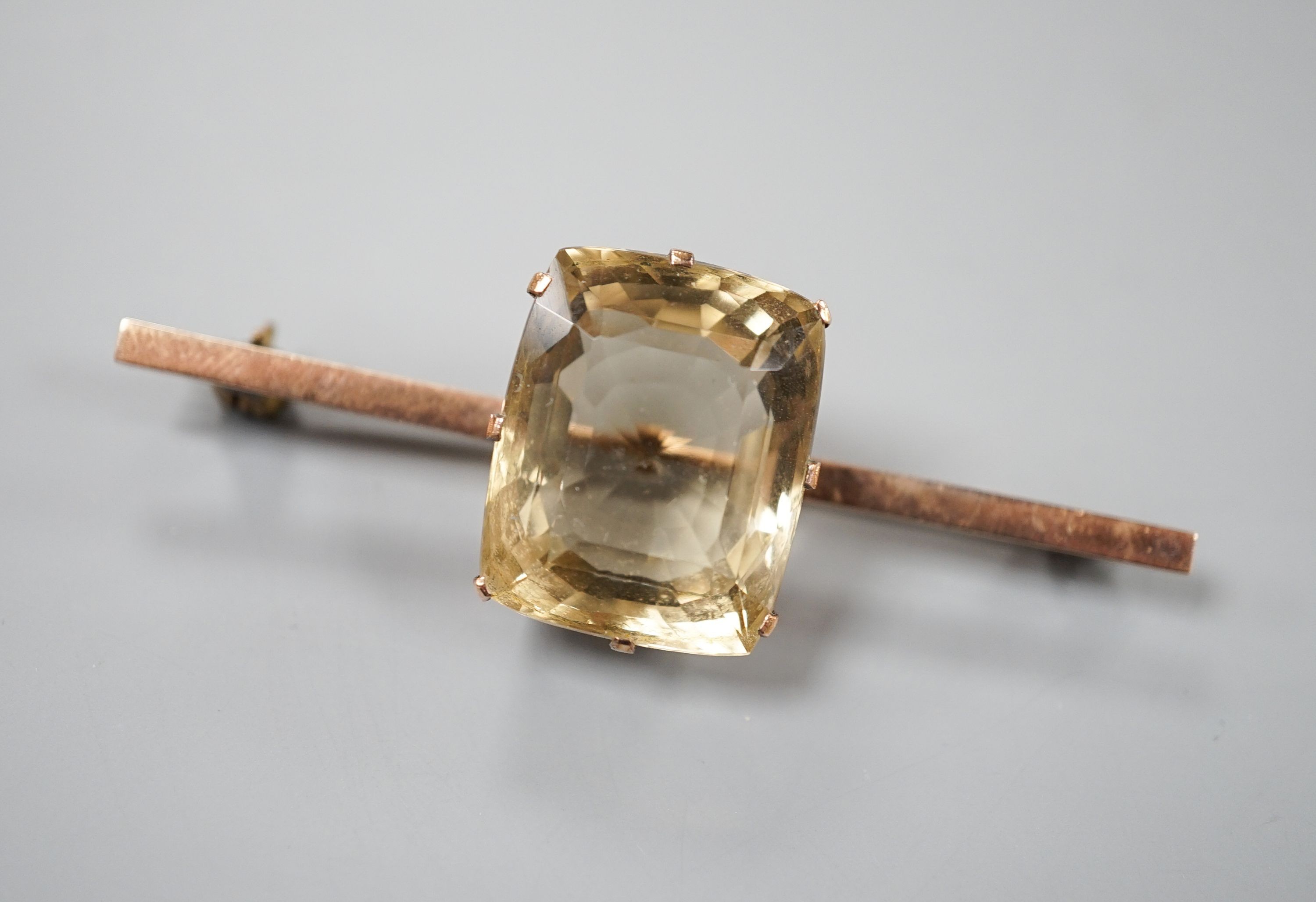 A yellow metal and citrine set bar brooch, 61mm, gross weight 11.9 grams.